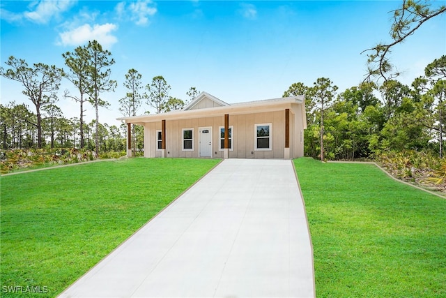 27159 Alhambra Dr, Punta Gorda, FL 33955 - view of front of house with board and batten siding, a front yard, and concrete driveway