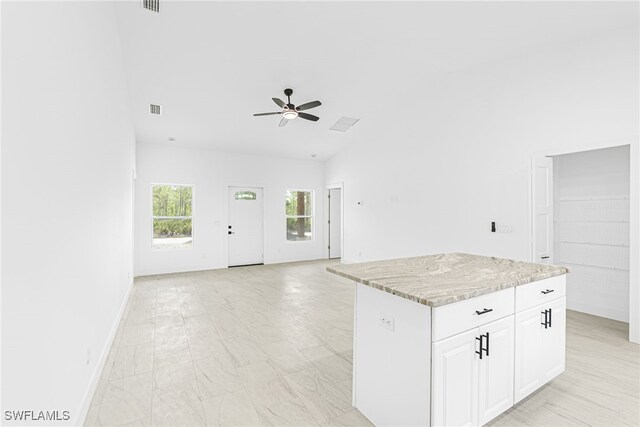 27159 Alhambra Dr, Punta Gorda, FL 33955 - kitchen with ceiling fan, open floor plan, a center island, white cabinets, and lofted ceiling