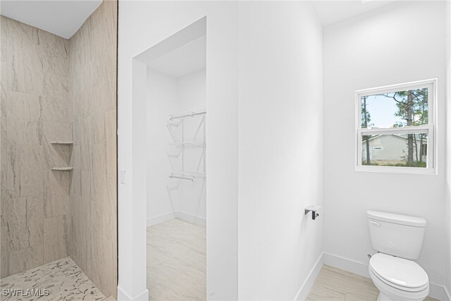 27159 Alhambra Dr, Punta Gorda, FL 33955 - bathroom featuring toilet, a tile shower, baseboards, a spacious closet, and marble finish flooring