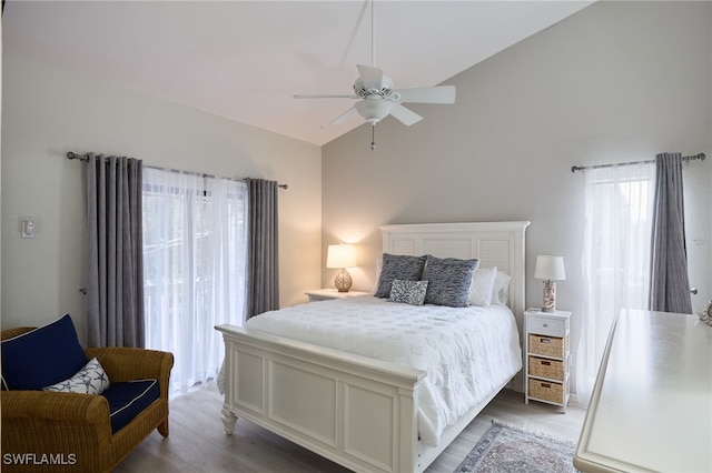 bedroom with ceiling fan, lofted ceiling, and light wood-type flooring