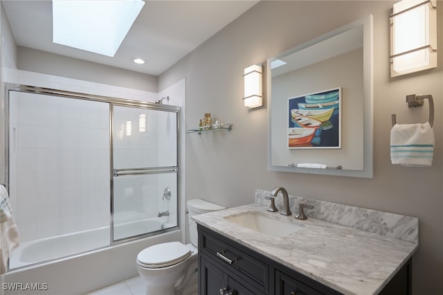 full bathroom with toilet, vanity, a skylight, and combined bath / shower with glass door