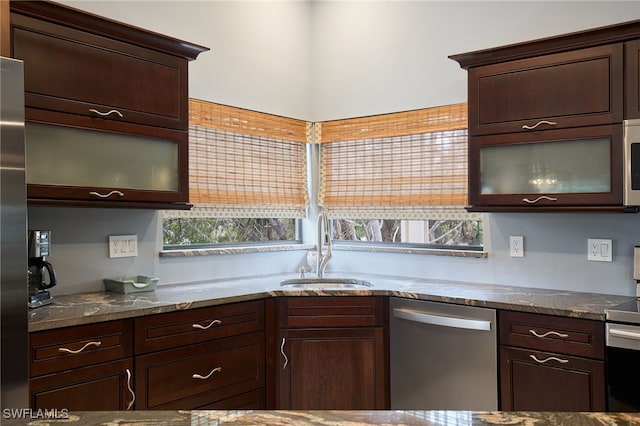 kitchen with appliances with stainless steel finishes, dark brown cabinets, and sink