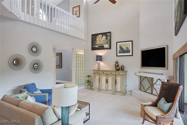 living room with ceiling fan and a high ceiling