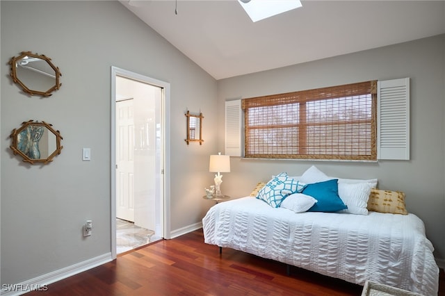 bedroom featuring hardwood / wood-style flooring, ensuite bathroom, and lofted ceiling with skylight