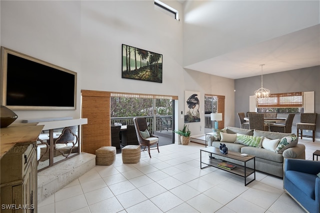 tiled living room featuring a towering ceiling and a chandelier