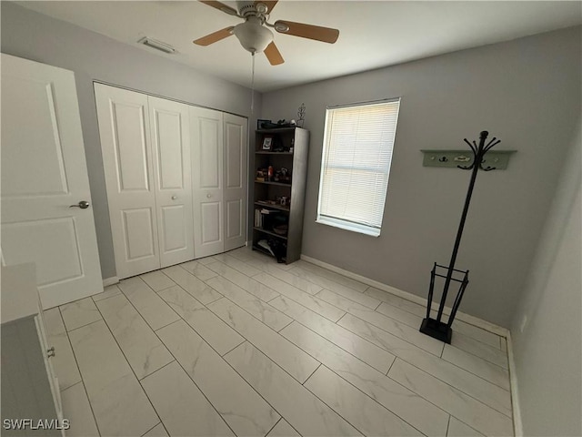 unfurnished bedroom featuring ceiling fan and a closet