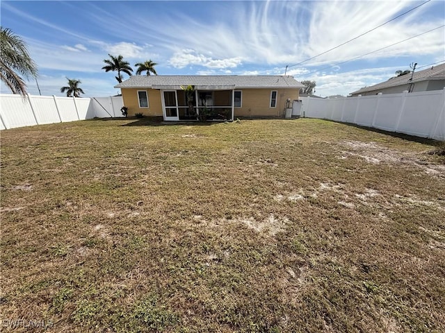 rear view of property featuring a sunroom and a yard