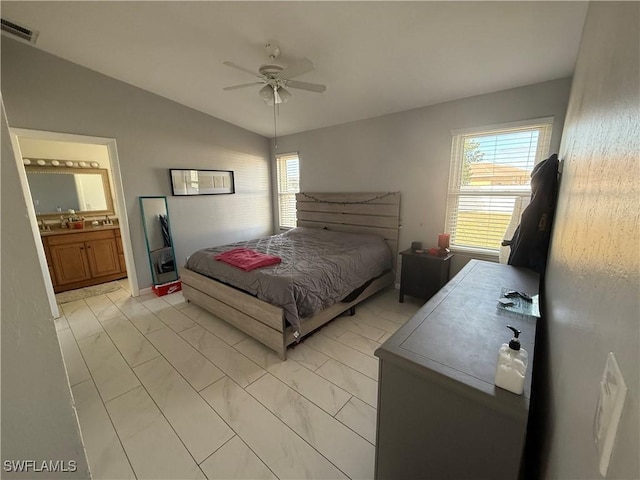 bedroom featuring ceiling fan, connected bathroom, and vaulted ceiling