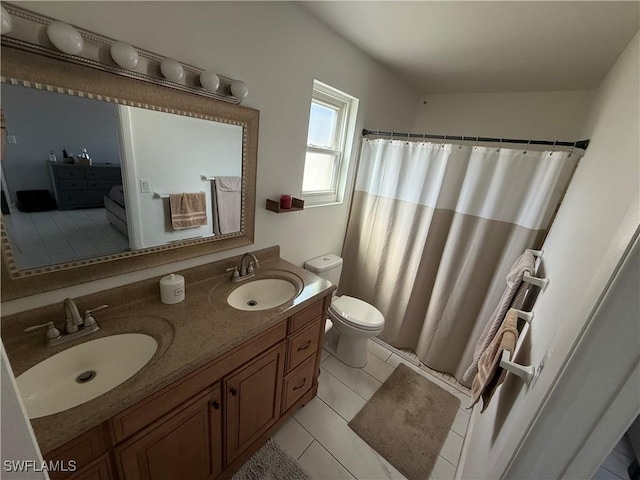 bathroom with tile patterned flooring, vanity, and toilet