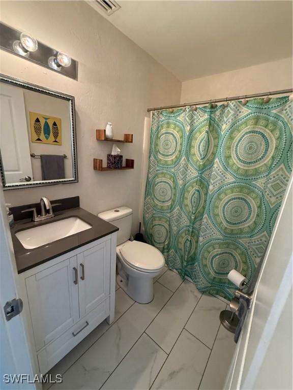 bathroom featuring vanity and toilet