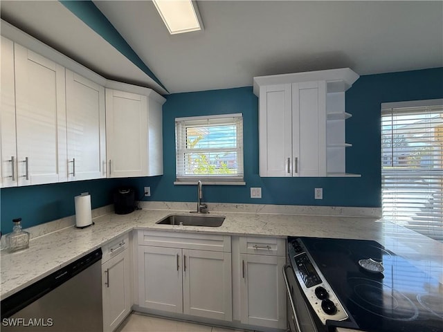 kitchen featuring vaulted ceiling, appliances with stainless steel finishes, sink, and white cabinets