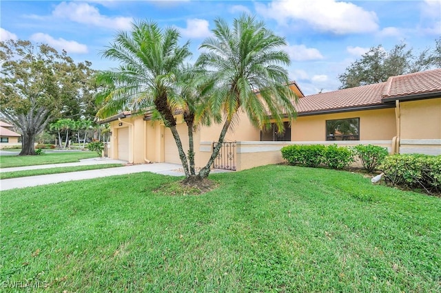 view of front of property featuring a garage and a front lawn