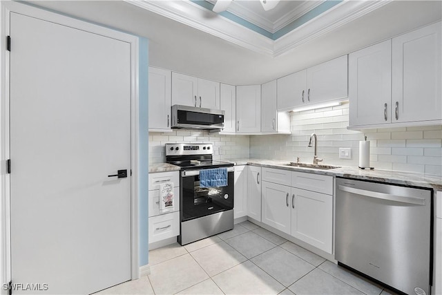 kitchen featuring sink, stainless steel appliances, white cabinetry, and light tile patterned flooring