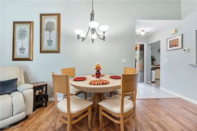 dining space with light hardwood / wood-style floors and a chandelier