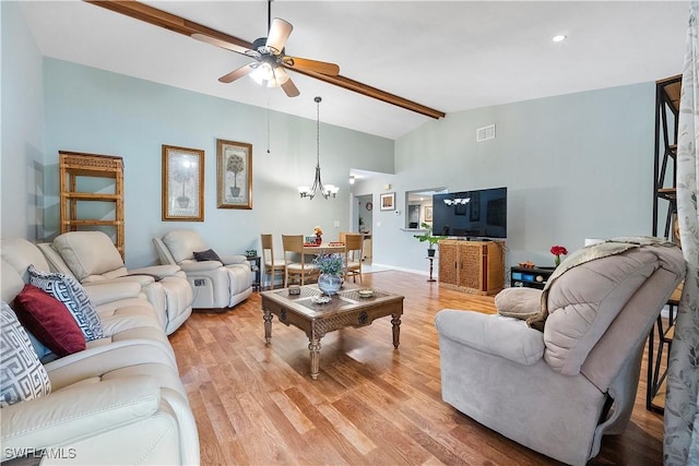 living room with ceiling fan with notable chandelier, vaulted ceiling with beams, and light hardwood / wood-style floors