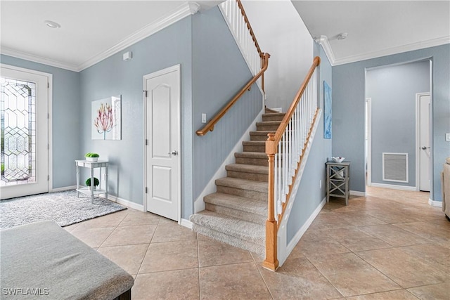 foyer entrance with light tile patterned flooring and crown molding