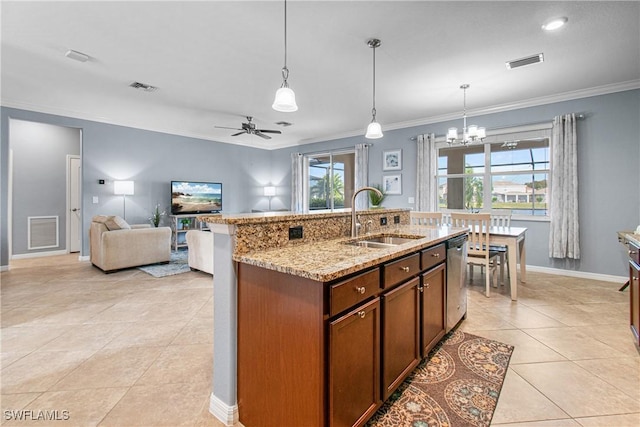 kitchen with ceiling fan with notable chandelier, pendant lighting, sink, a kitchen island with sink, and light stone counters