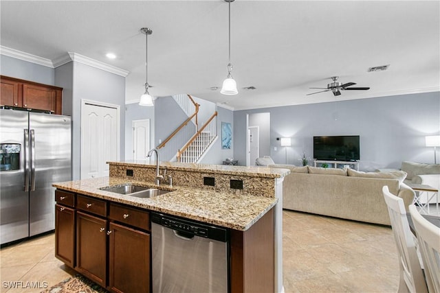 kitchen with pendant lighting, stainless steel appliances, sink, ceiling fan, and a center island with sink