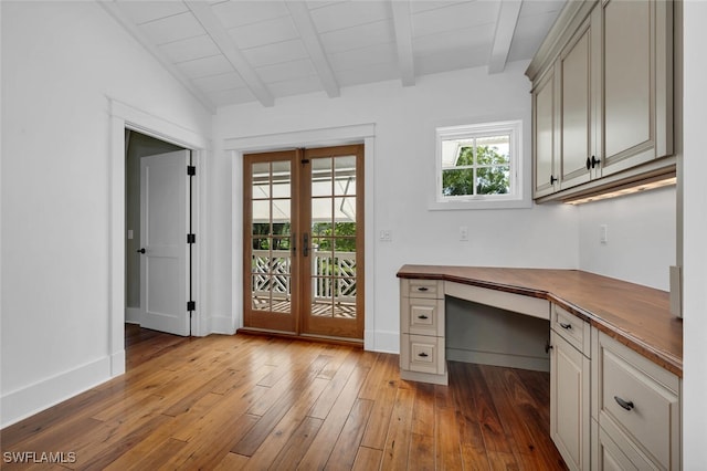 unfurnished office with built in desk, vaulted ceiling with beams, light hardwood / wood-style floors, wooden ceiling, and french doors