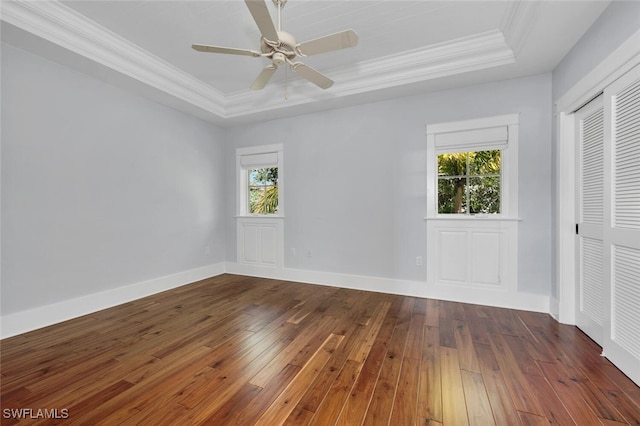 interior space with ceiling fan, crown molding, dark hardwood / wood-style flooring, and a tray ceiling