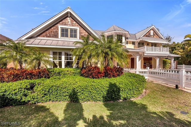 view of front facade with a front yard and a balcony