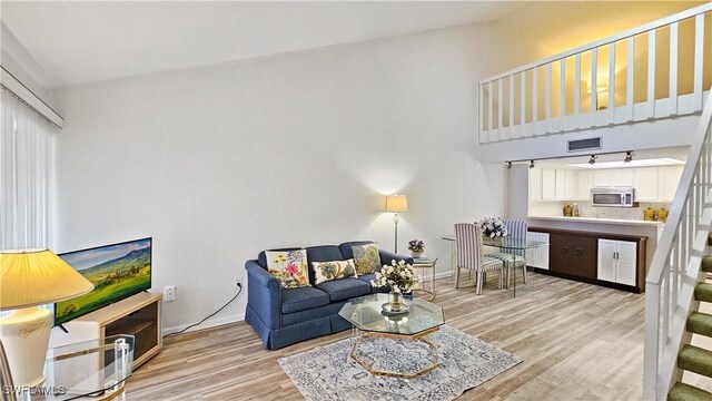 living room with vaulted ceiling and light hardwood / wood-style floors