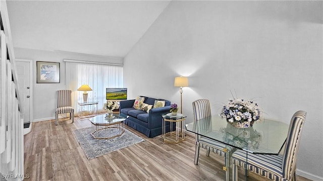 living room featuring vaulted ceiling and light hardwood / wood-style flooring