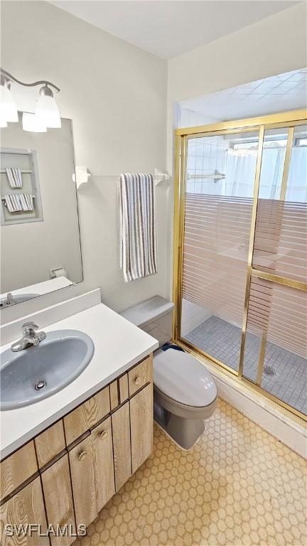 bathroom featuring walk in shower, vanity, and toilet