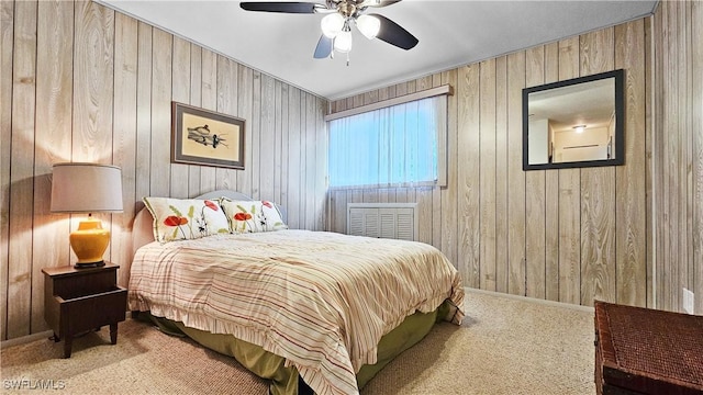 bedroom featuring ceiling fan, light carpet, and wood walls