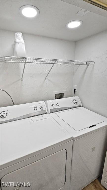 washroom with wood-type flooring and independent washer and dryer