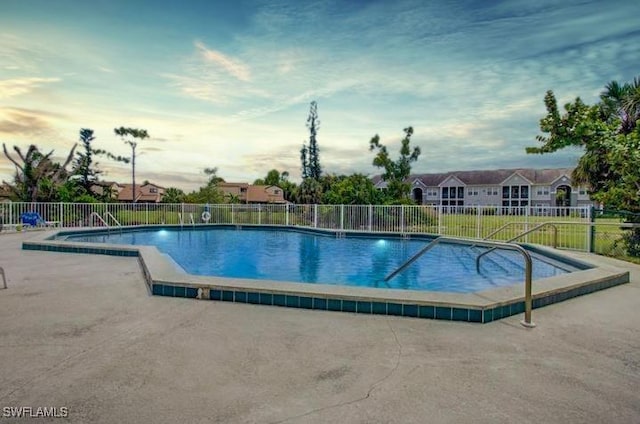 pool at dusk featuring a patio