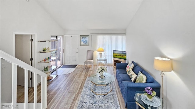 living room with wood-type flooring and high vaulted ceiling