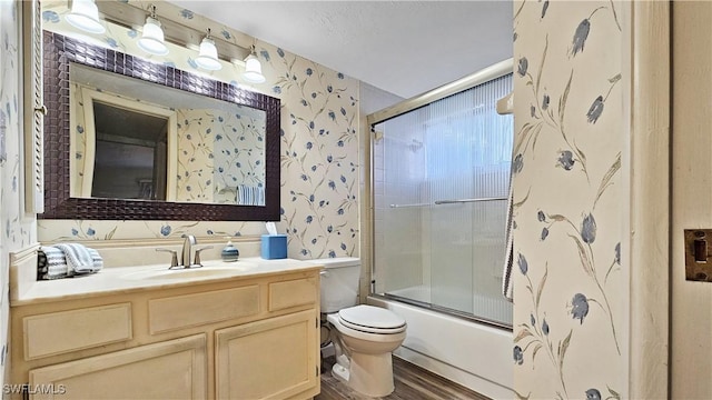 full bathroom with vanity, combined bath / shower with glass door, wood-type flooring, and toilet