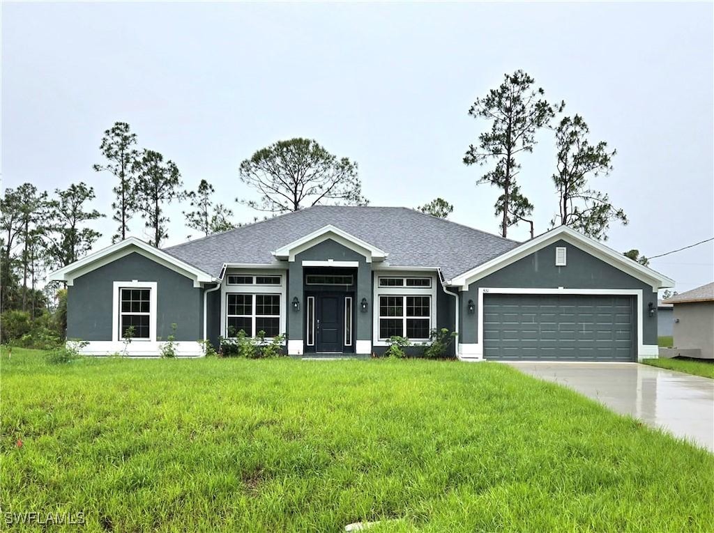 511 Windermere Dr, Lehigh Acres, FL 33972 - ranch-style house with an attached garage, a front lawn, concrete driveway, stucco siding, and roof with shingles