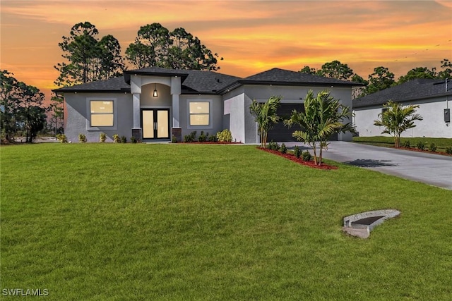 view of front of property featuring a garage and a lawn