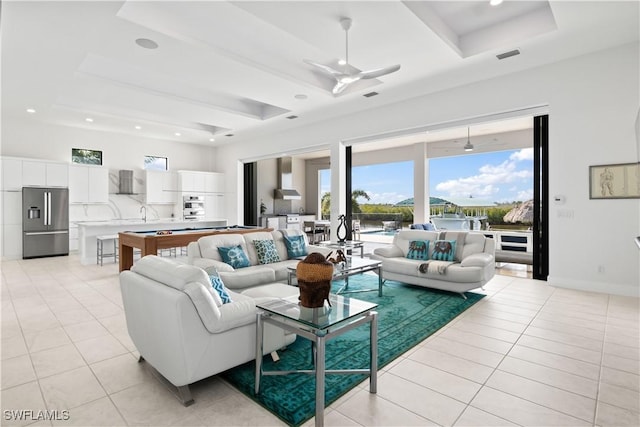 tiled living room with ceiling fan, billiards, and a raised ceiling