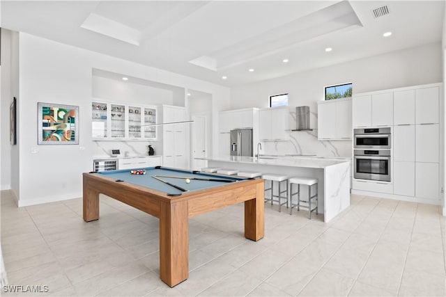 rec room featuring sink, pool table, and a tray ceiling