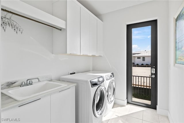 clothes washing area featuring cabinets, washer and clothes dryer, sink, and light tile patterned floors