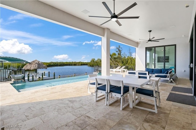 view of patio featuring outdoor lounge area, pool water feature, ceiling fan, and a water view