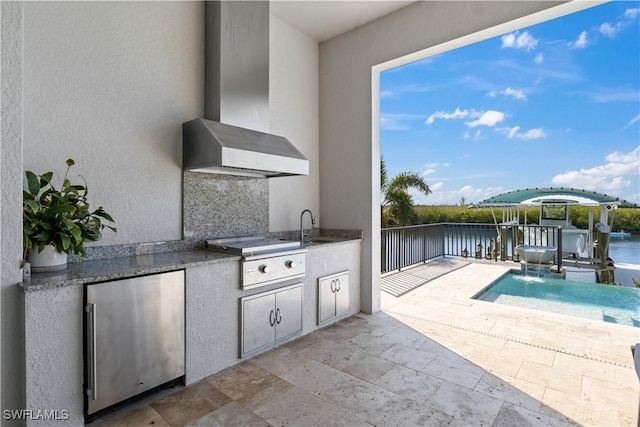 view of patio with a water view, area for grilling, and sink