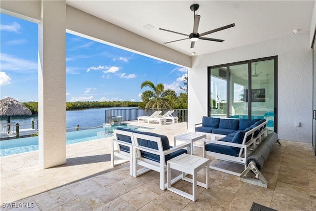 view of patio with outdoor lounge area, ceiling fan, and a water view