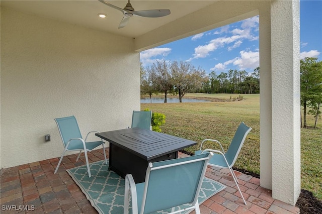 view of patio featuring ceiling fan and a water view