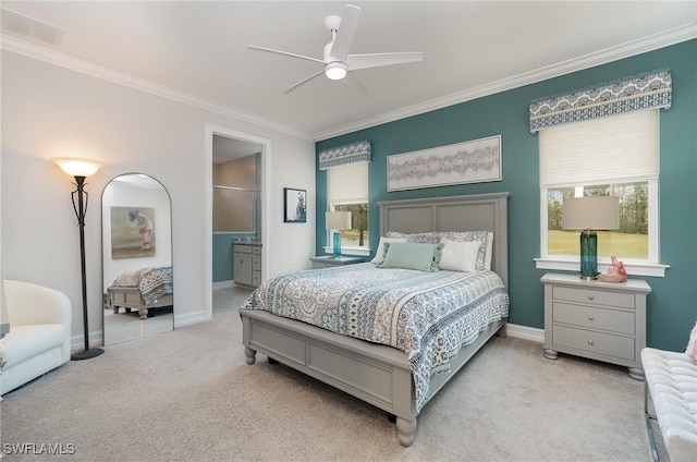 bedroom featuring crown molding, light colored carpet, ceiling fan, and ensuite bathroom