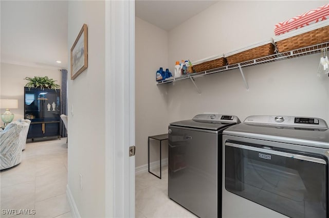 washroom featuring washer and clothes dryer and light tile patterned floors