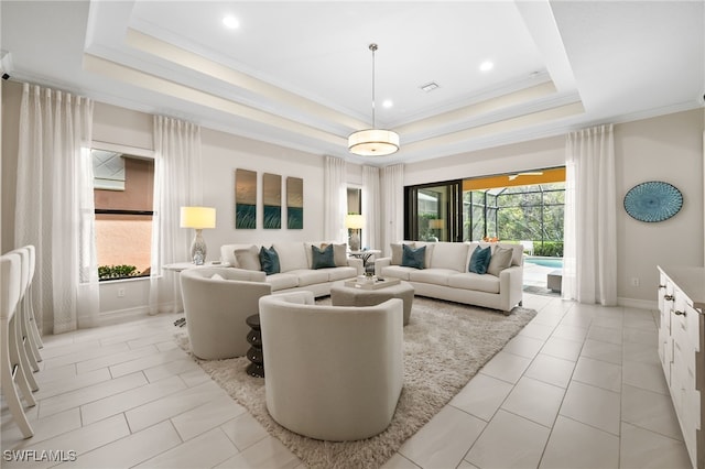 tiled living room with a tray ceiling and ornamental molding