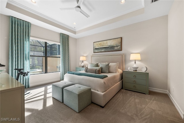 bedroom featuring ceiling fan, light carpet, crown molding, and a tray ceiling