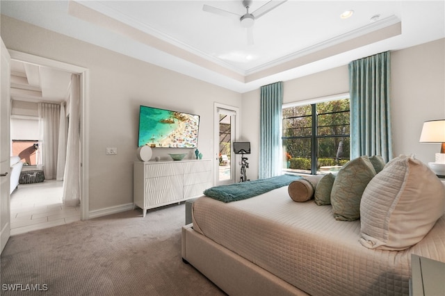 carpeted bedroom with ceiling fan and a tray ceiling