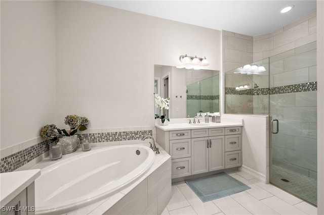 bathroom featuring tile patterned floors, vanity, and shower with separate bathtub