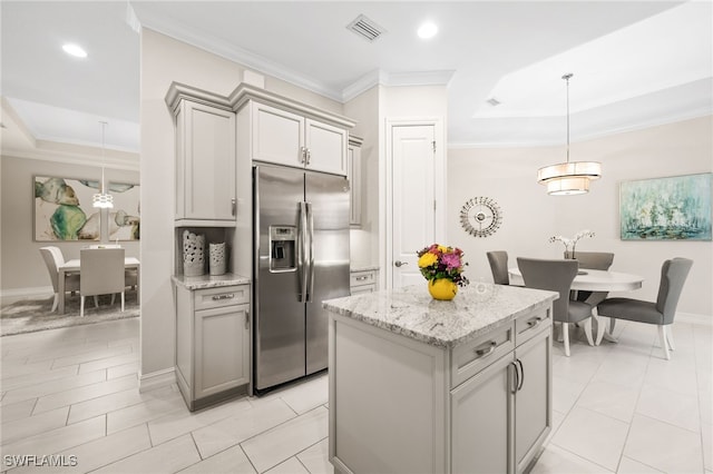 kitchen with gray cabinets, pendant lighting, light stone countertops, stainless steel fridge with ice dispenser, and ornamental molding