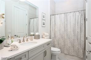 bathroom featuring toilet, vanity, and walk in shower